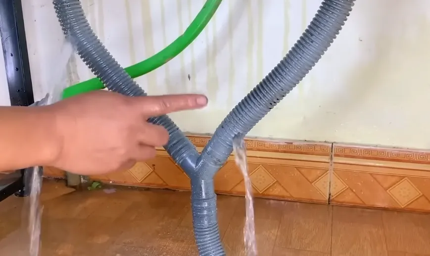 Gray flexible drain hoses joined at a Y fitting, part of a home drain line like those in Tahoe Donner vacation rentals