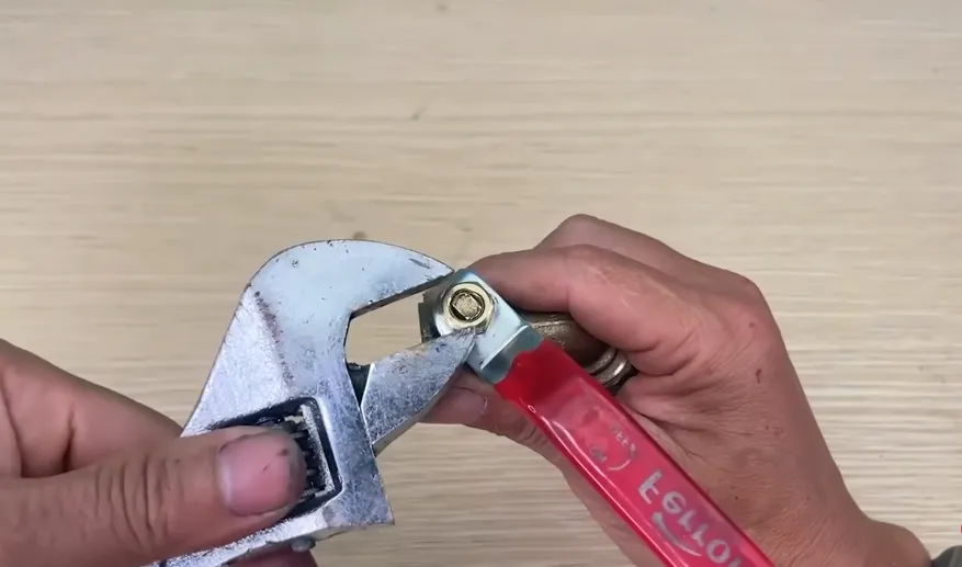 Adjustable wrench on a leaking pipe fitting during a hidden water leak repair in Glenshire, Truckee