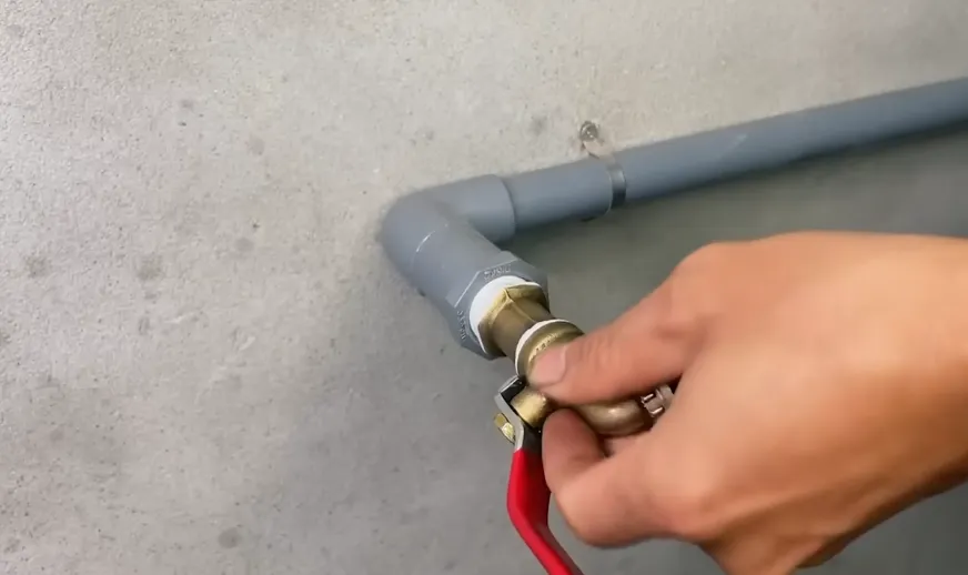 Brass shutoff valve being connected to a water line, the valve a Northstar rental local contact should know